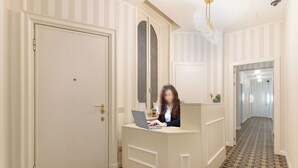 A reception area with a desk, a door, and a patterned floor. - Montello Suites Foresteria Lombarda (Milan)