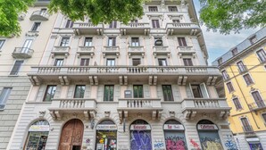 A multi-story building with ground-floor shops including a tobacconist, a restaurant, and a bar. - Montello Suites Foresteria Lombarda (Milan)
