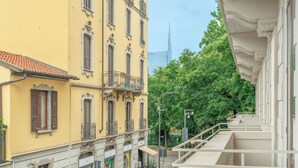A yellow building with balconies and a green door. - Montello Suites Foresteria Lombarda (Milan)