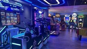 An arcade with neon lights and various gaming machines, including a sniper game and a Minecraft-themed machine. - Immaculate 3-bed Static Caravan in Skegness (Skegness)