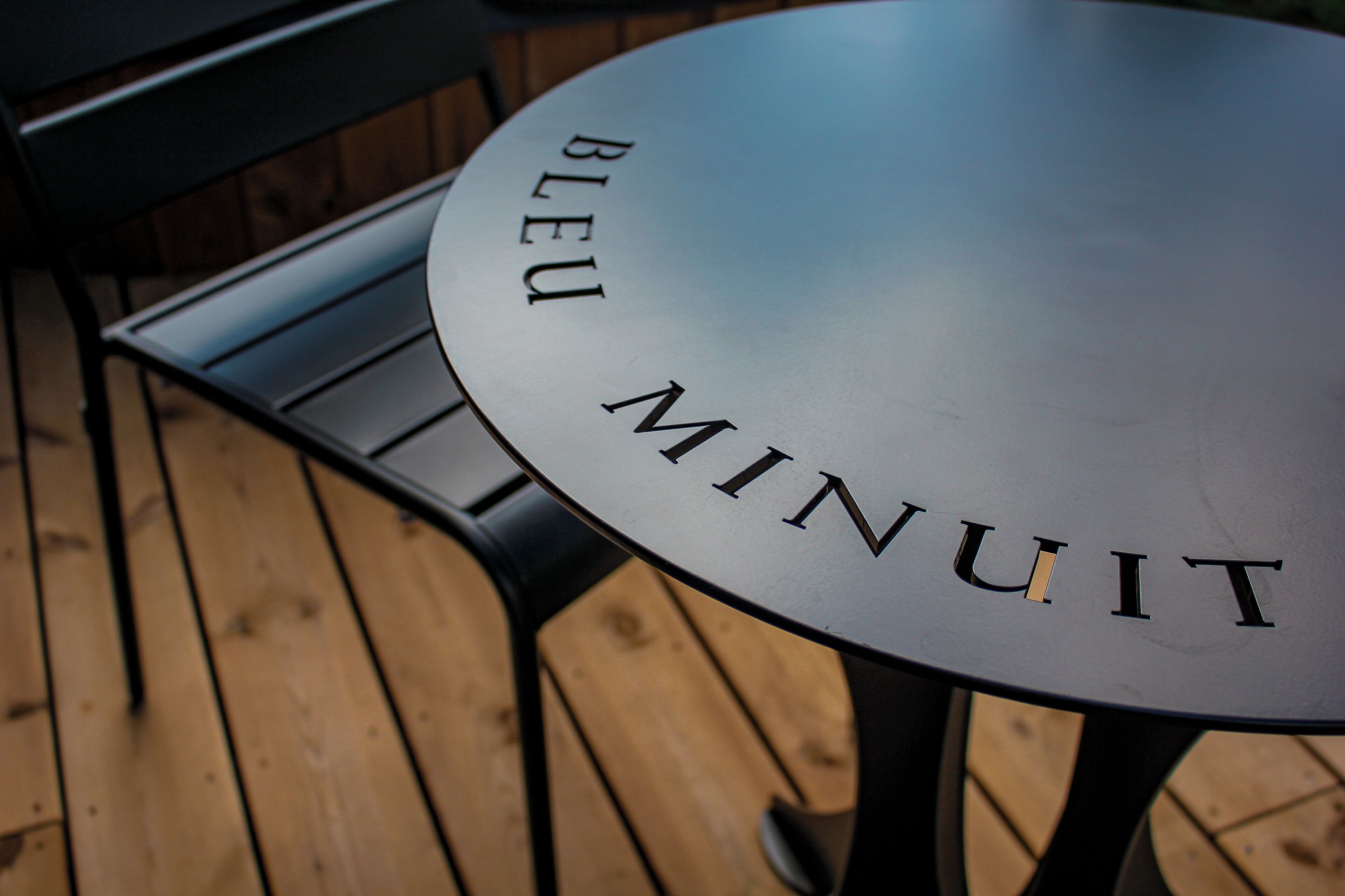 A round table with the words "BLEU MINUIT" engraved on its surface.