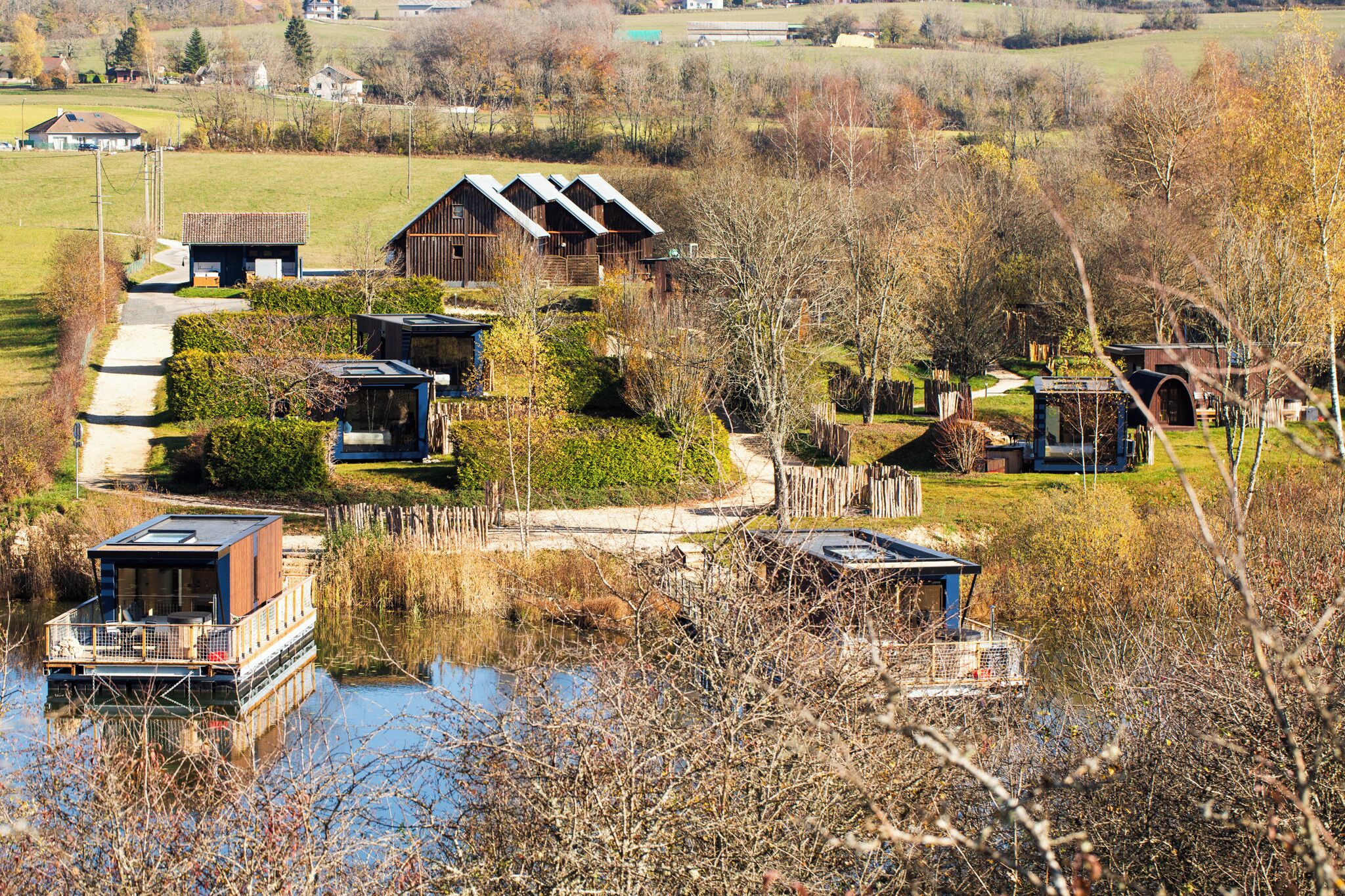 Une propriété au bord du lac comprenant plusieurs chalets, un quai et un petit bateau.
