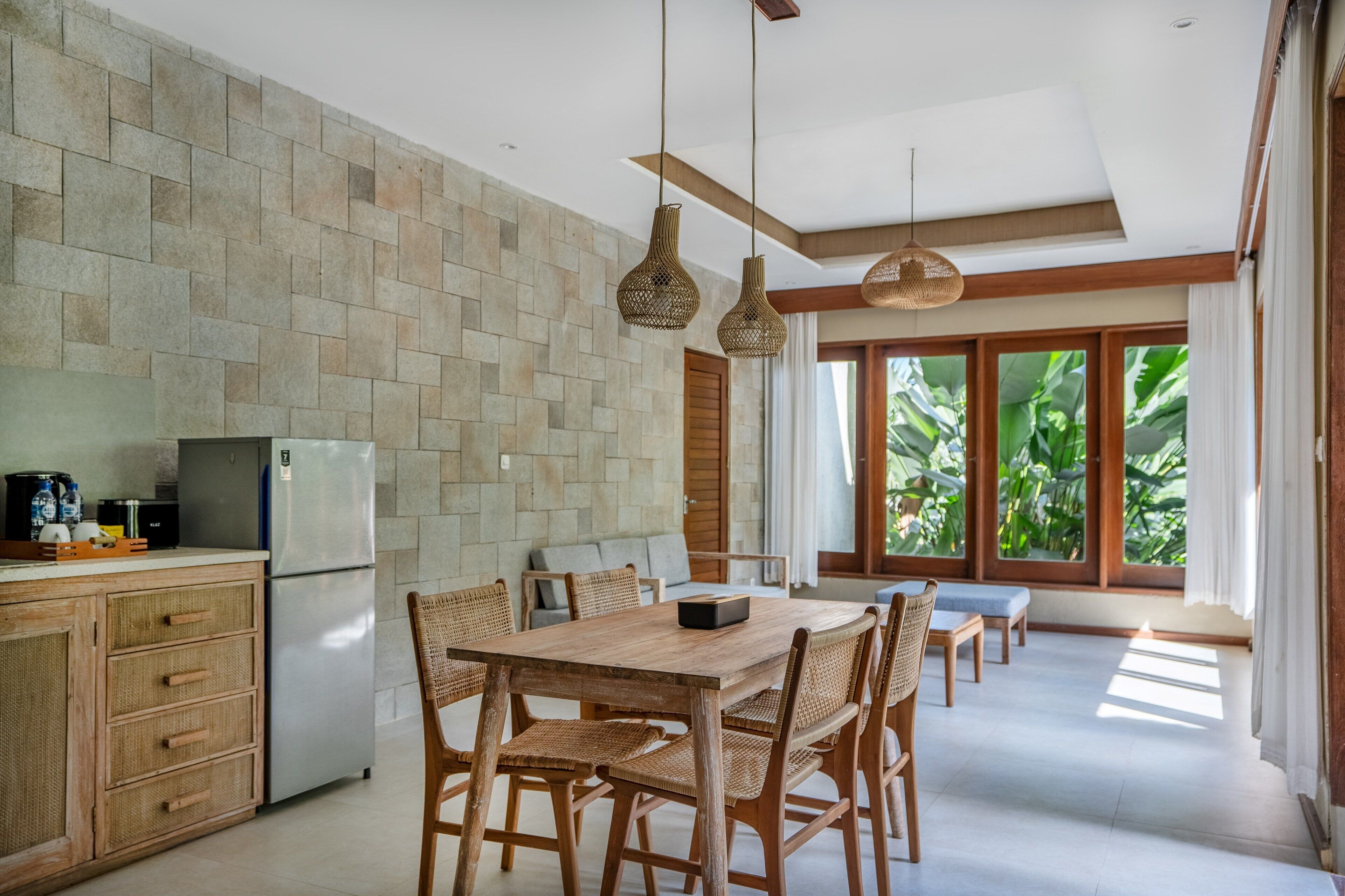 Una cocina moderna con protector de piedra, mesa de comedor de madera y sillas de mimbre.