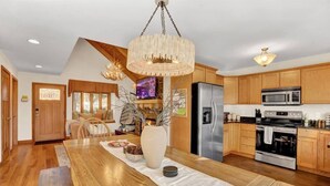 Une cuisine spacieuse dotée d’armoires en bois, d’appareils électroménagers en acier inoxydable et d’une grande table à manger.