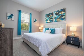 A bedroom with a large bed, two bedside tables, and artwork on the walls. - Cozy Villa 5 min to Disney (Kissimmee)