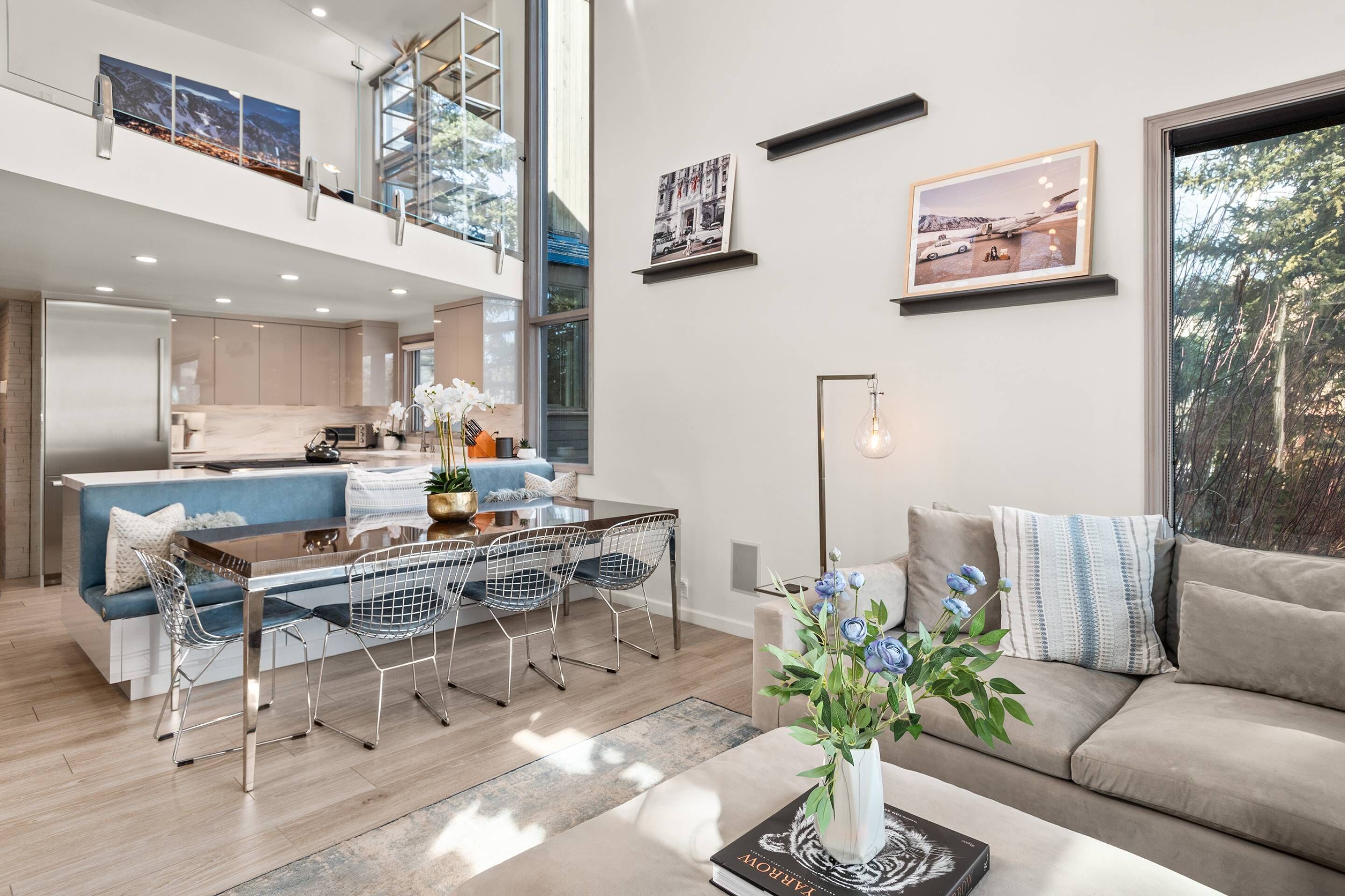 Un salón moderno y abierto con una mesa de comedor, sillas, un sofá y una mesa de centro.