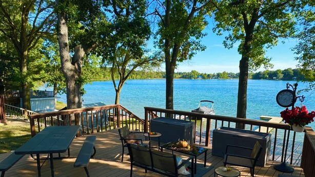 A wooden deck with outdoor furniture, overlooking a lake. - T’is Our Cottage:Modern Lakefront fall colors & football relax Just off toll Rd  (Howe)