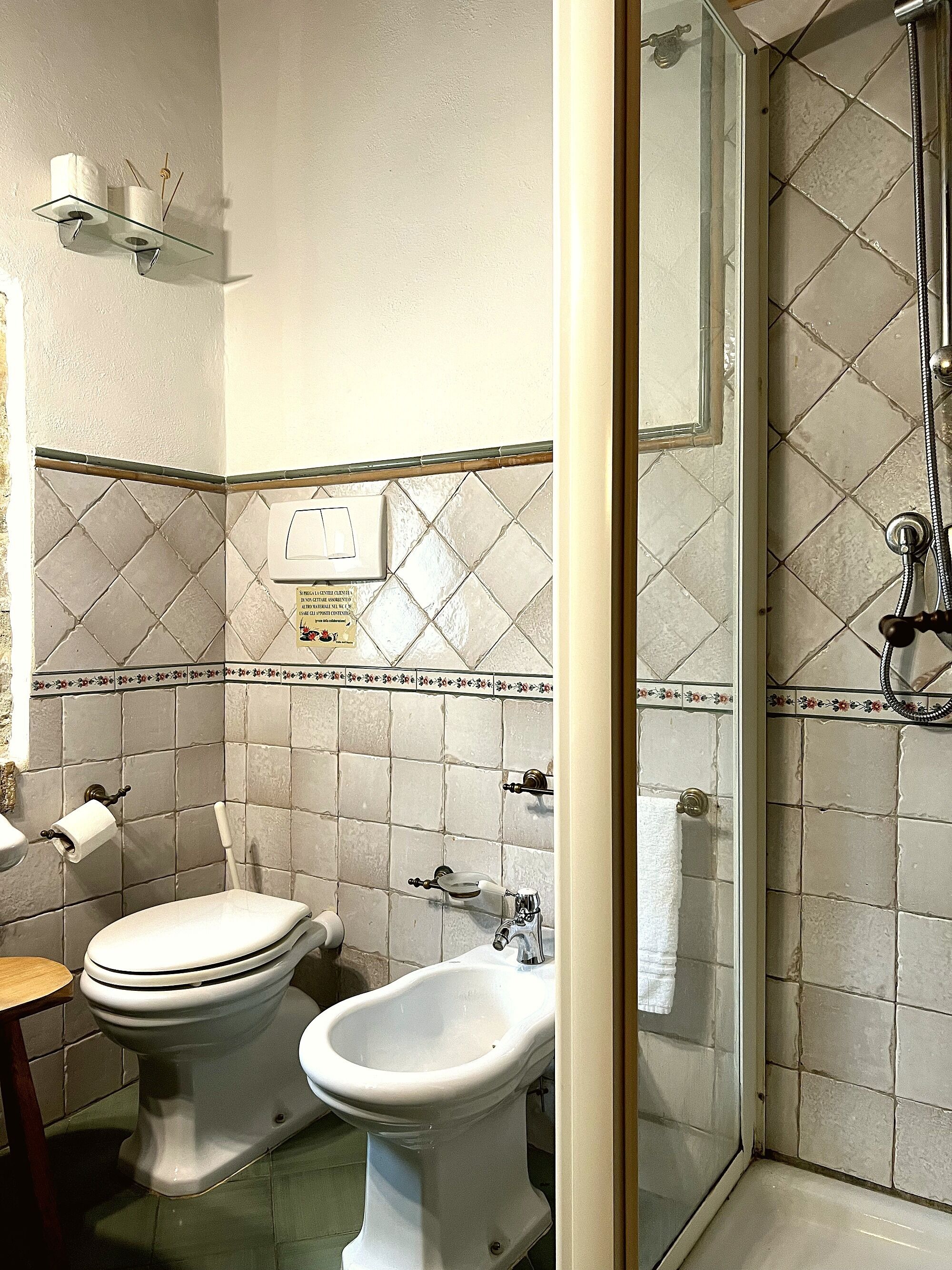 Une salle de bain équipée de toilettes, d’un bidet et d’une douche.