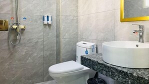 A bathroom with a toilet, a sink, and a shower. - Gutian Fuxin Hotel (Gutian)