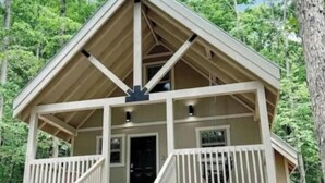 A cabin with a front porch, a staircase, and a garage. - Robin's Nest Sleeps 6 (Mentone)