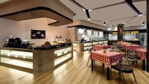A restaurant interior with a counter, tables, and chairs. - Fengdu Hotel (Harbin) (Harbin)