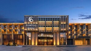 A modern hotel with a prominent logo, a glass facade, and a well-lit entrance. - Fengdu Hotel (Harbin) (Harbin)