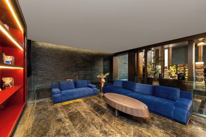 Una sala de estar moderna con un sofá seccional, una mesa de centro y una pared decorada en rojo.