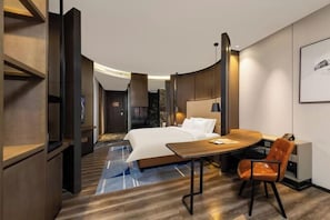 A hotel room with a bed, a round table, a chair, and a desk. - Fengdu Hotel (Harbin) (Harbin)