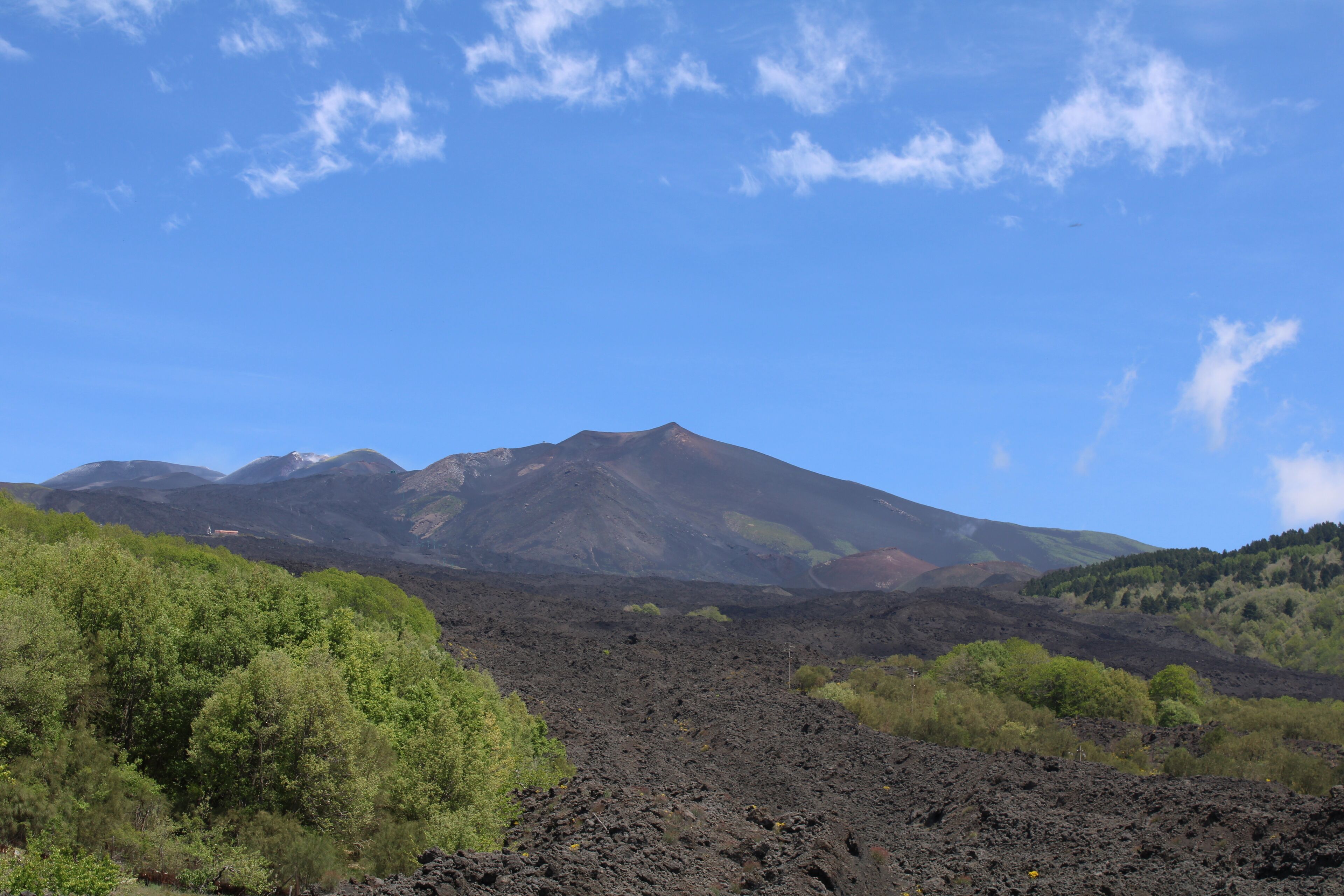 A mountainous landscape with a prominent volcano in the background.