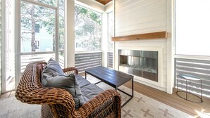 Une pièce chaleureuse avec un canapé en osier, une table basse en bois foncé et une cheminée.
