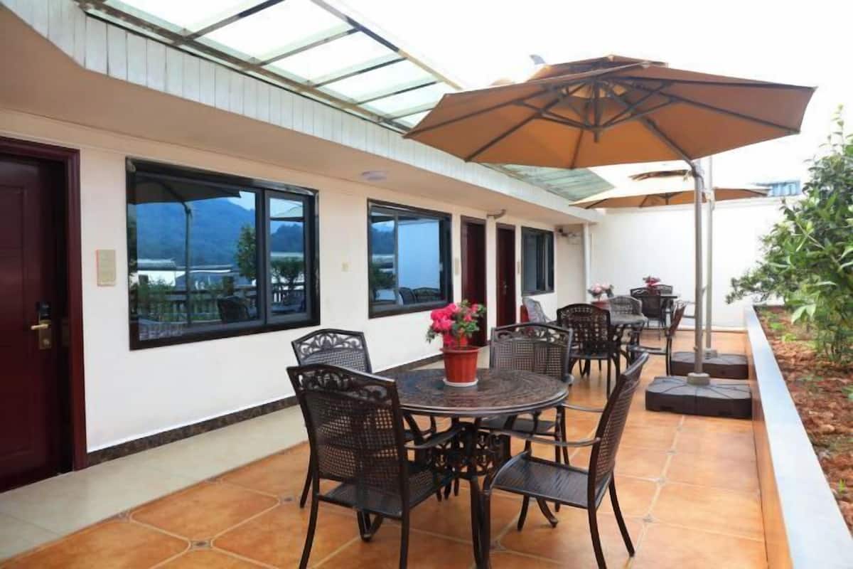 A patio area with a round table, chairs, and a large umbrella.
