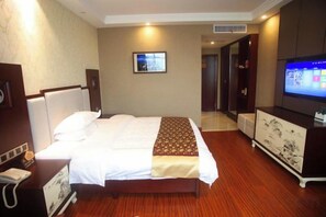 A hotel room with a bed, a television, a desk, and a mirror. - Xinning Xiaobaihua Resort Hotel (Xinning)