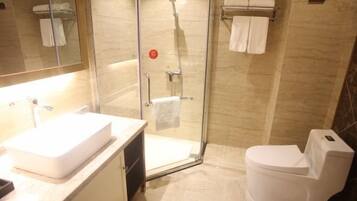 A bathroom with a glass-enclosed shower, a white sink, and a toilet.
