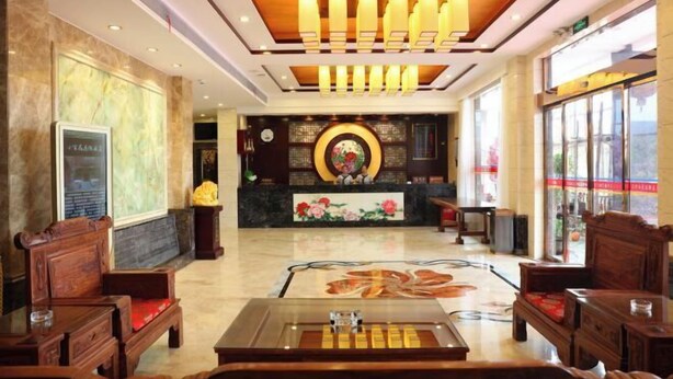 A lobby with wooden furniture, a reception desk, and a decorative ceiling. - Xinning Xiaobaihua Resort Hotel (Xinning)