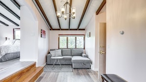 Ein gemütliches Wohnzimmer mit einem Ecksofa, einer Holzbank und einem kleinen runden Tisch.