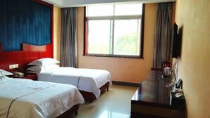 Habitación de hotel con dos camas, un ventanal grande, un televisor de pantalla plana y un escritorio con silla.
