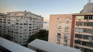 Vista de un edificio residencial de varios pisos con fachada curva, ventanas amplias y unidades de aire acondicionado.