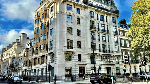 Un immeuble à étages, de style architectural classique, qui se distingue par son entrée d’angle imposante et ses nombreux balcons.