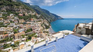 A coastal town with buildings along the hillside and a view of the sea. - Casa Bijou (Positano)
