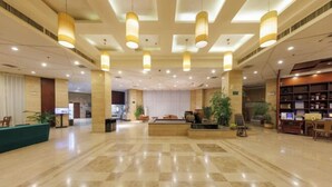 A spacious lobby with a reception desk, check-in counters, and a seating area. - Hequan Farm (Bengbu)
