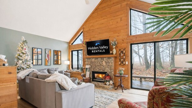 Ein modernes Wohnzimmer mit Kamin, großem Fenster und einem Schild für Hidden Valley Rentals.