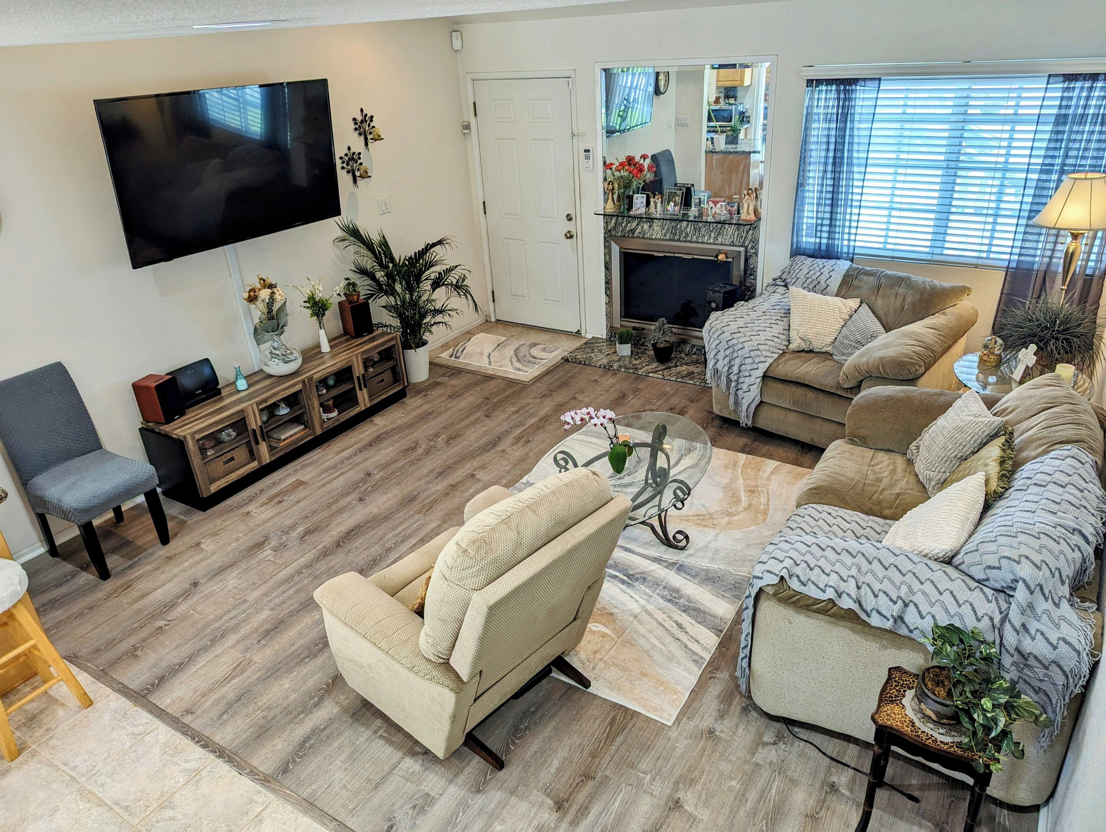 A living room with a flat-screen TV, a fireplace, and a sofa set.