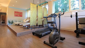 A gym with exercise equipment, a treadmill, and a stationary bike. - Dal Molin Apartment, Lago di Garda, Jacuzzi (Desenzano Del Garda)