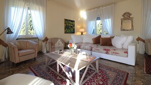 A living room with a sofa, armchairs, a coffee table, and a patterned rug. - Provenzale Apartment, Lago di Garda, Jacuzzi (Desenzano Del Garda)