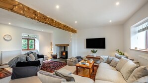 Ein gemütliches Wohnzimmer mit Kamin, Sofas, Couchtisch und Fernseher.
