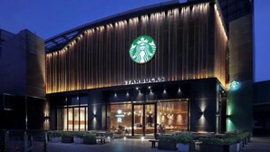 A Starbucks store with a modern facade, large windows, and outdoor seating area. - Orange Hotel (Suzhou University East Ring Road Subway Station) (Suzhou)