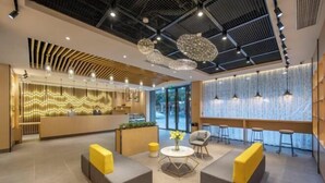 A modern lobby with seating areas, a reception desk, and a large window with a view. - Orange Hotel (Suzhou University East Ring Road Subway Station) (Suzhou)