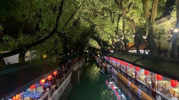 A narrow waterway lined with traditional wooden boats and red lanterns, suggesting a cultural or historical setting. - Orange Hotel (Suzhou University East Ring Road Subway Station) (Suzhou)