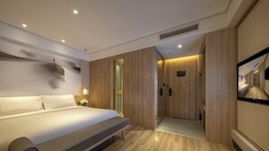A modern bedroom with a bed, wooden paneling, and a television. - Orange Hotel (Suzhou University East Ring Road Subway Station) (Suzhou)