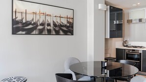 A modern kitchen with black cabinets, a stainless steel range hood, and a built-in oven. - Immaculate 2-bed Apartment in Prime Central London (London)