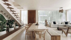 A modern living room with a staircase, a dining area, and a sofa set. - Casa Mazuri Jungle Villa Beach Club Access (Tulum)
