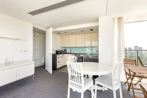 Enjoy a meal for two at the dining table, with a city view from the large window.
