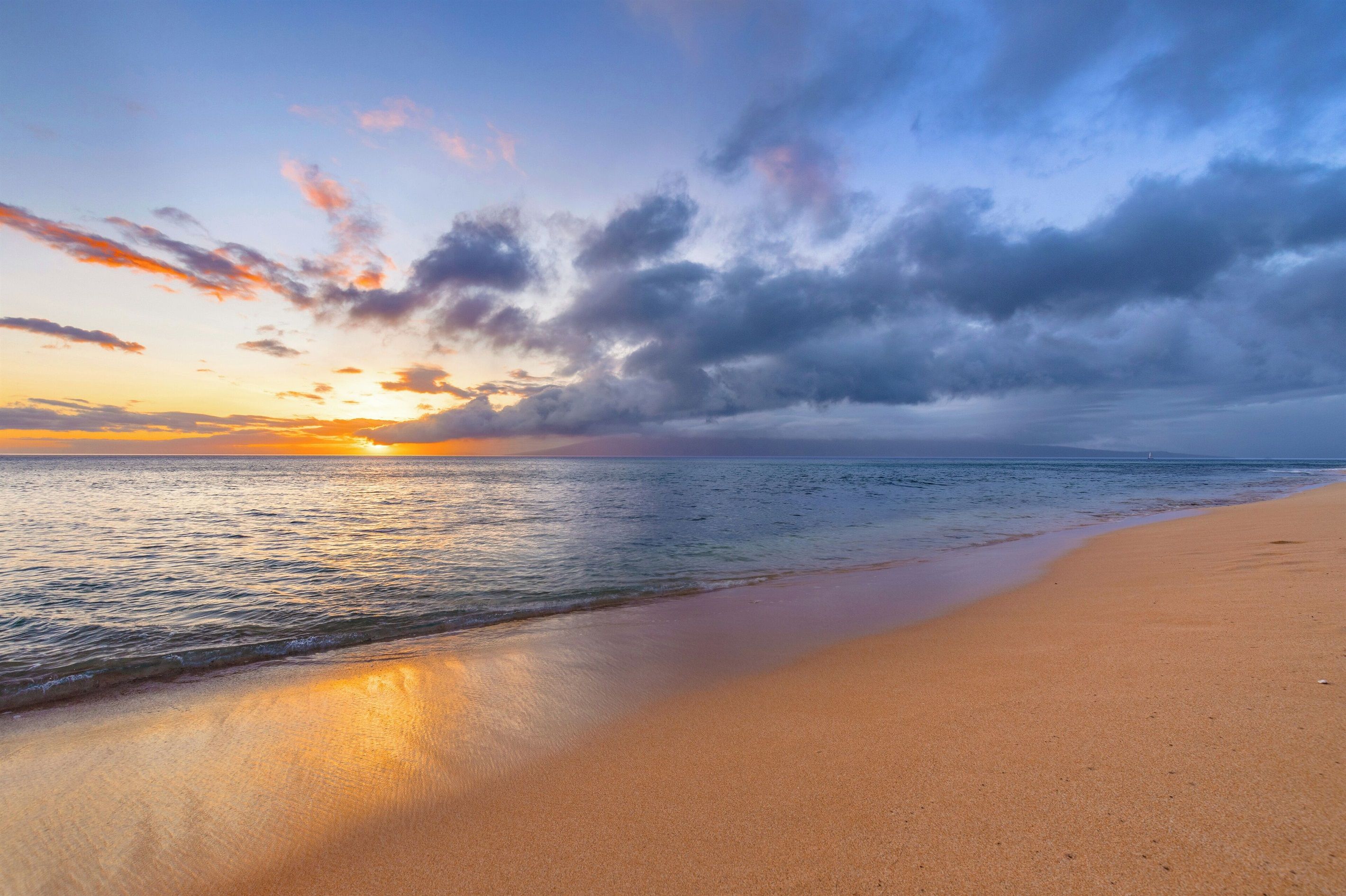 A beach with a sunset and calm sea.