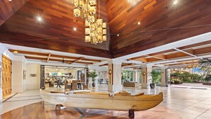 Eine geräumige Lobby mit einem hölzernen Bootskunstwerk, hohen Decken und einem modernen Kronleuchter.