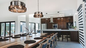 A modern kitchen with dark wood cabinets, stainless steel appliances, and a large island. - Casa Samaria (Valle de Guadalupe)