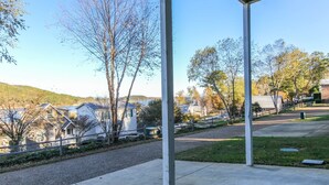 Un espacio al aire libre cubierto, con vista a casas y colinas al fondo.