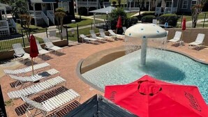 Un espace piscine avec des chaises longues et des parasols.
