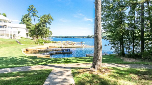A lakeside property with a swimming pool, a dock, and a large white building. - House #10 Paradise Found (pet friendly) private pier (Leesburg)