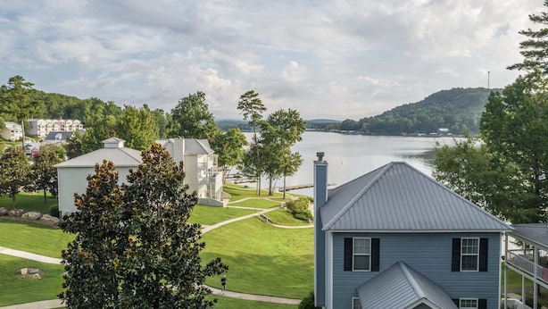 Una zona residencial con casas, un lago y un paisaje montañoso al fondo.