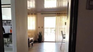 Een ruime hal met een houten vloer die leidt naar een balkon met uitzicht.